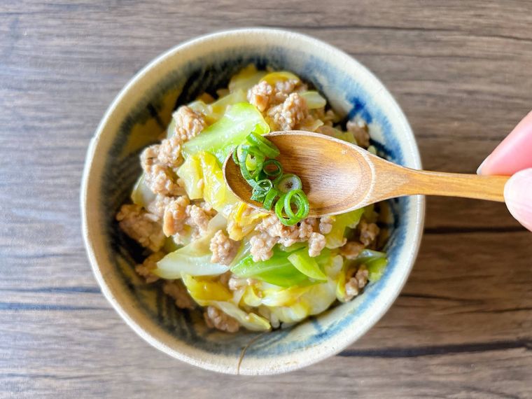 器にあんかけを盛り小口ねぎをトッピングする様子