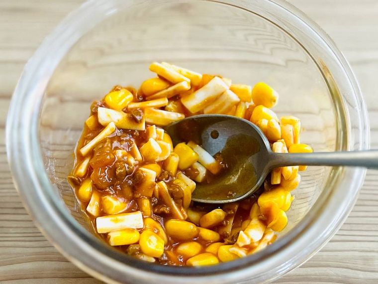 チーズ、ミートソース、コーンを混ぜ合わせている様子