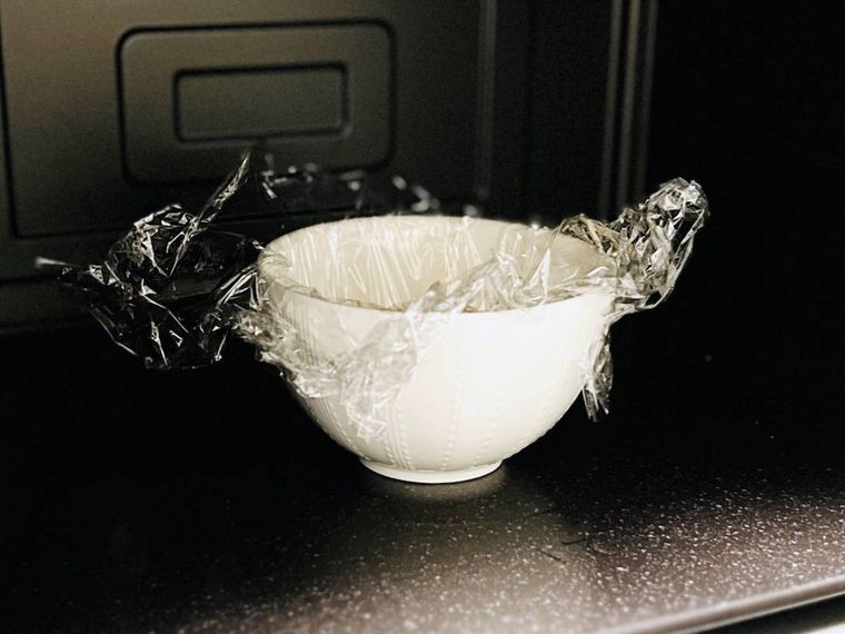 ピザまんの材料が入った耐熱容器を、電子レンジの庫内に入れた様子