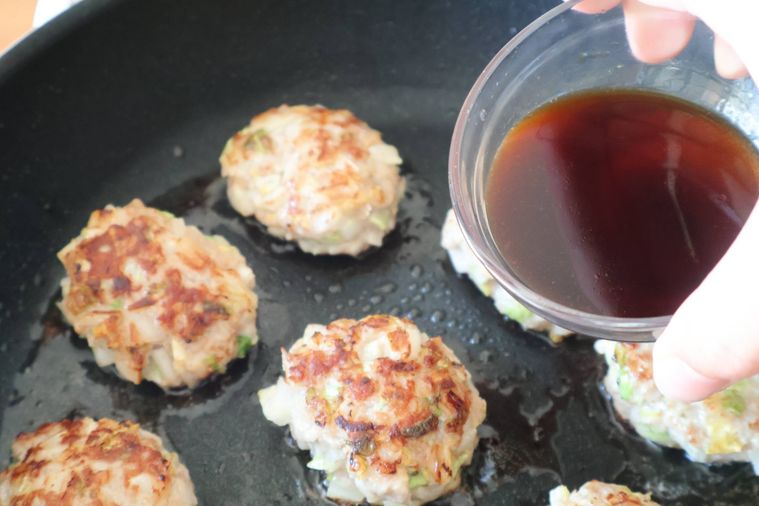 フライパンに調味料を加えている