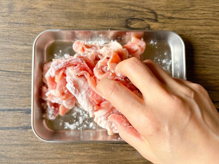 豚こま肉に片栗粉をまぶす様子