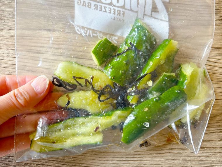 塩こんぶとごま油、きゅうりを混ぜる様子