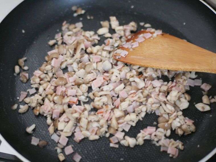 フライパンでしめじとベーコンを炒める様子