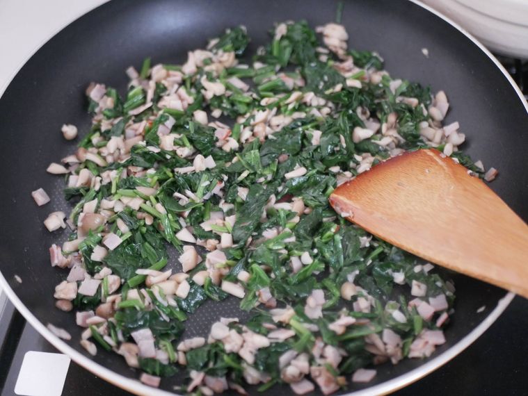 フライパンでしめじとベーコン、ほうれん草を炒める様子