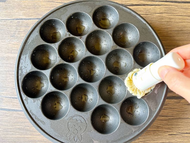 たこ焼き器に油をひく様子