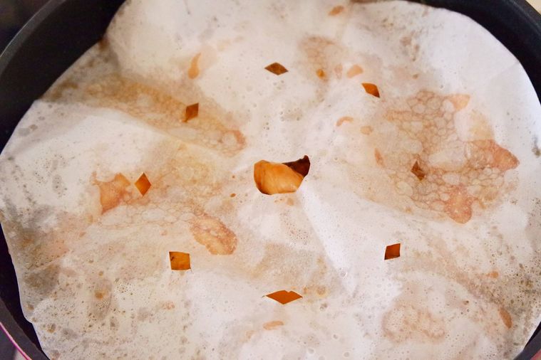 フライパンに落し蓋をして鶏手羽元を煮ている様子