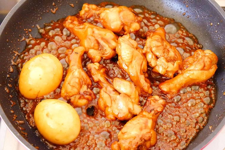 鶏手羽元に煮汁を絡めている様子