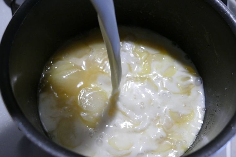 鍋に牛乳を加える様子