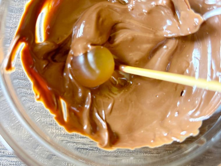 グミをチョコレートに入れてコーティングする様子