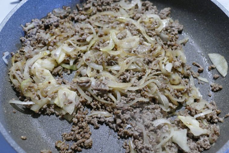 合い挽き肉と玉ねぎ、にんにくをフライパンで炒める様子