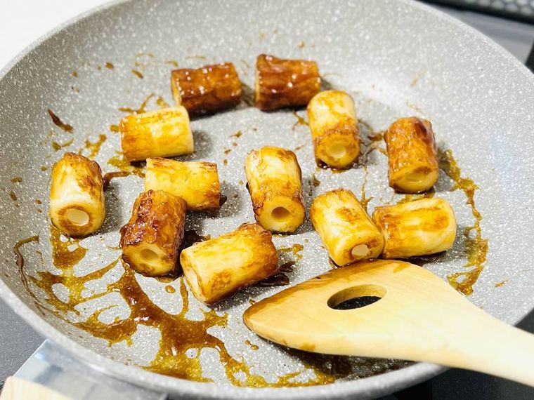 炒めたちくわにたこ焼きソースを絡めている様子