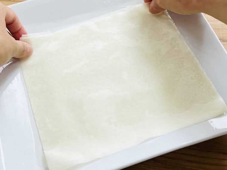 春巻の皮を水にくぐらせている様子