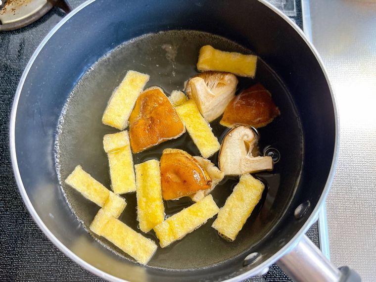 鍋でしいたけと油揚げを煮る様子