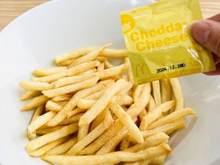 マックフライポテトにチェダーチーズパウダーをかけている様子