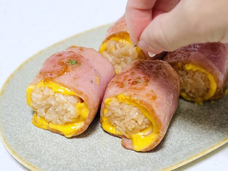 ベーコンチーズおにぎりにパセリを散らしている様子