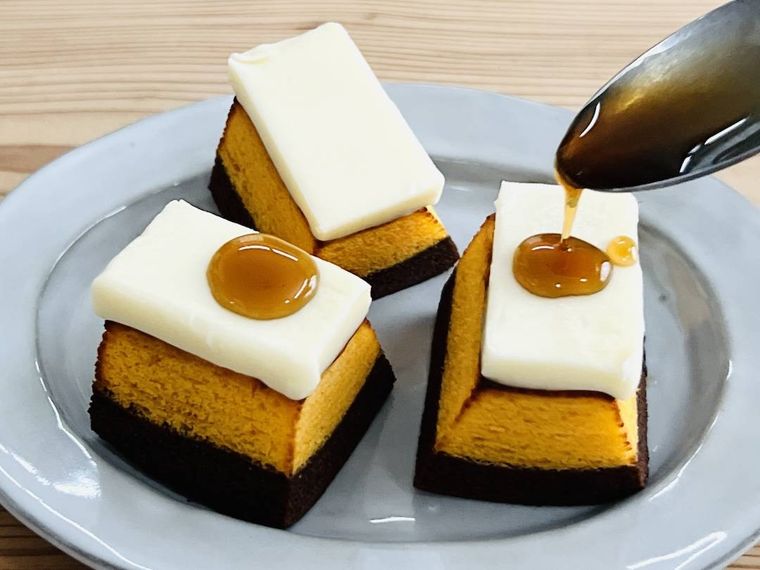バターをのせた鉄分がとれるバウム チョコオレンジに、メープルシロップをかけている様子