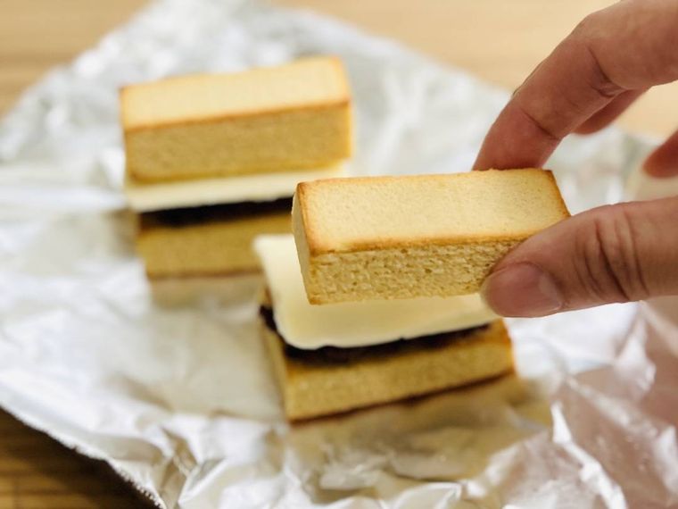 バウムクーヘンで粒あんとバターをサンドしている様子