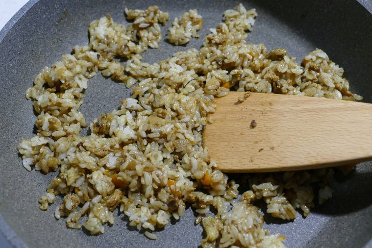 カレーとごはんをヘラで混ぜながら炒める様子