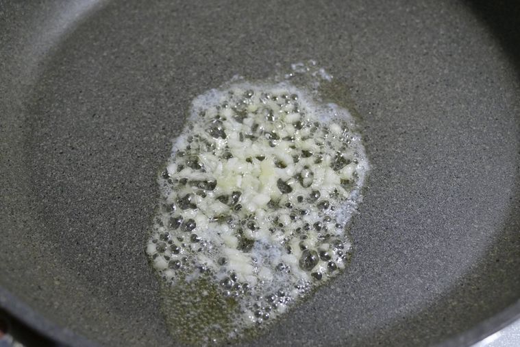 バターでみじん切りのにんにくを炒める様子