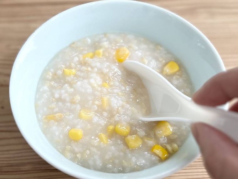 お粥にコーンを混ぜている様子