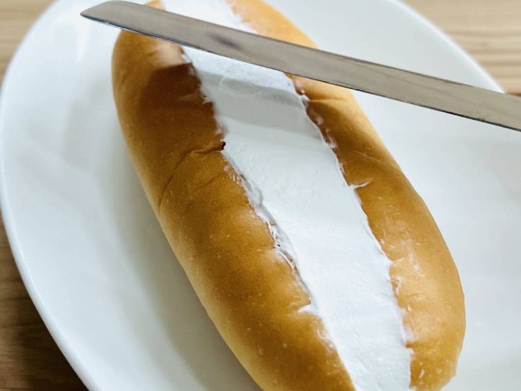 パンに絞ったホイップクリームを平らにならしている様子