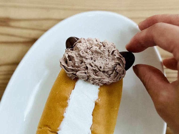 ホットドッグパンにきのこ型チョコクッキーを刺している様子