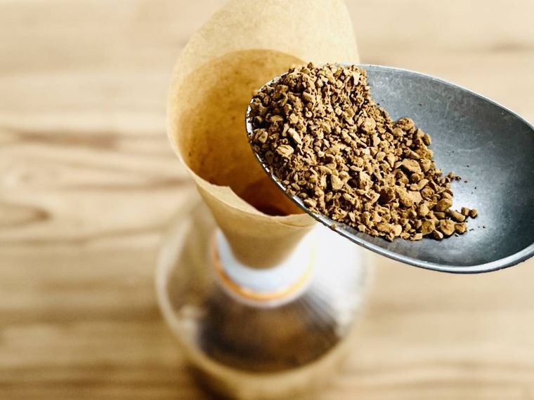 空のペットボトルにインスタントコーヒーを入れている様子