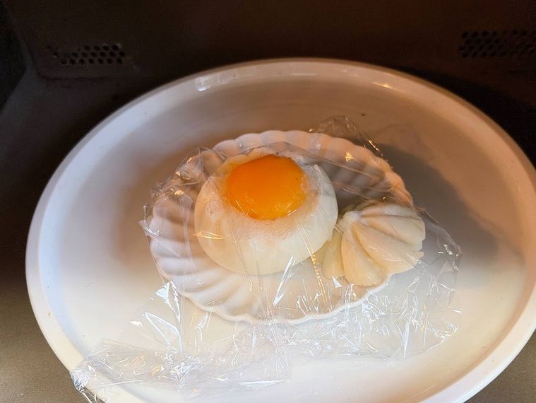 レンジで卵をのせた肉まんを加熱する様子