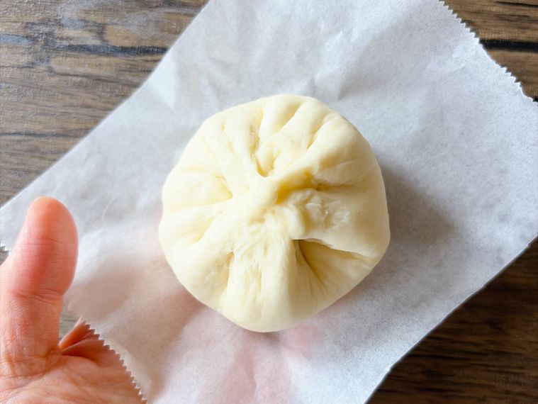肉まんをクッキングシートにおいたもの