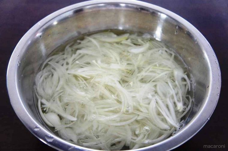 玉ねぎをボウルに入った塩水につけている様子