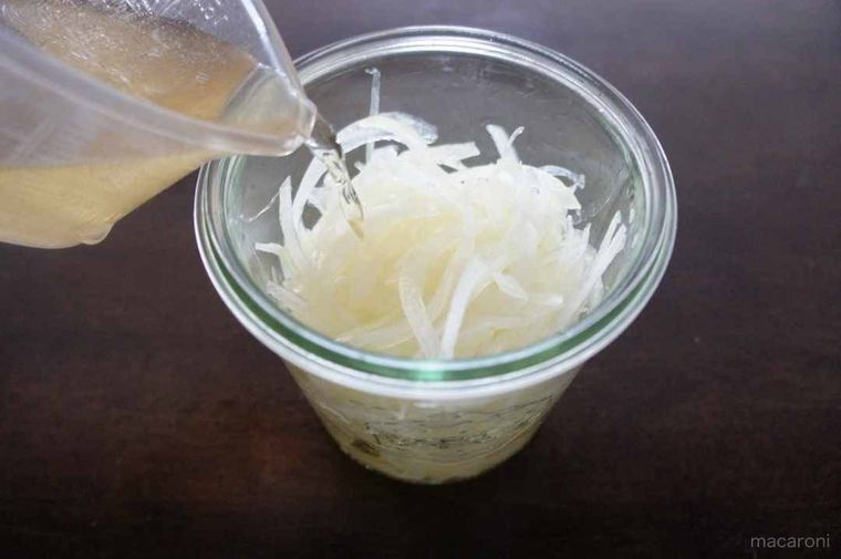 ボウルに入った玉ねぎに調味液を加えている様子