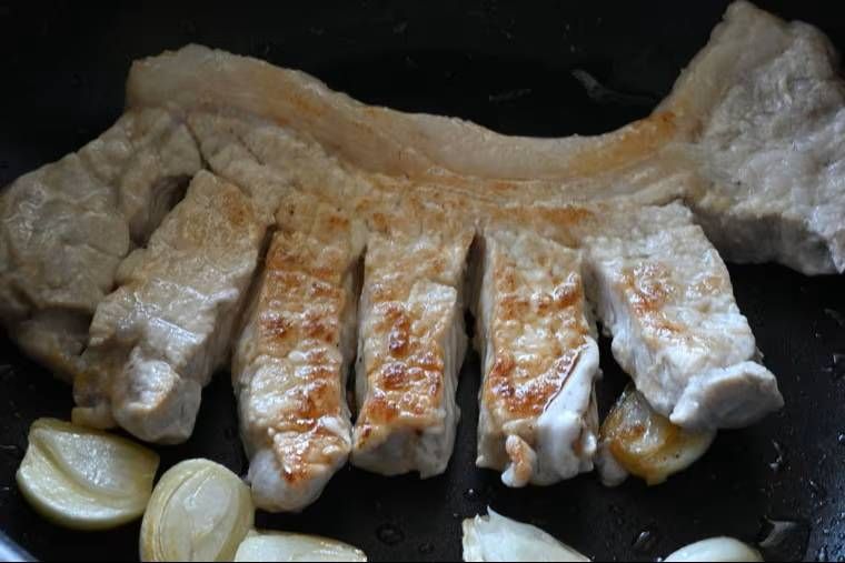フライパンでトンテキを焼いている様子