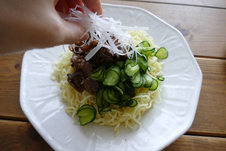 焼肉冷やし中華を皿に盛り付ける様子
