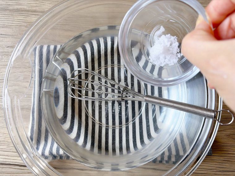 ボウルに入った砂糖水に塩を加える様子