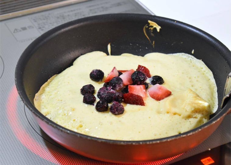 フライパンのホットケーキ生地にのせたミックスベリー