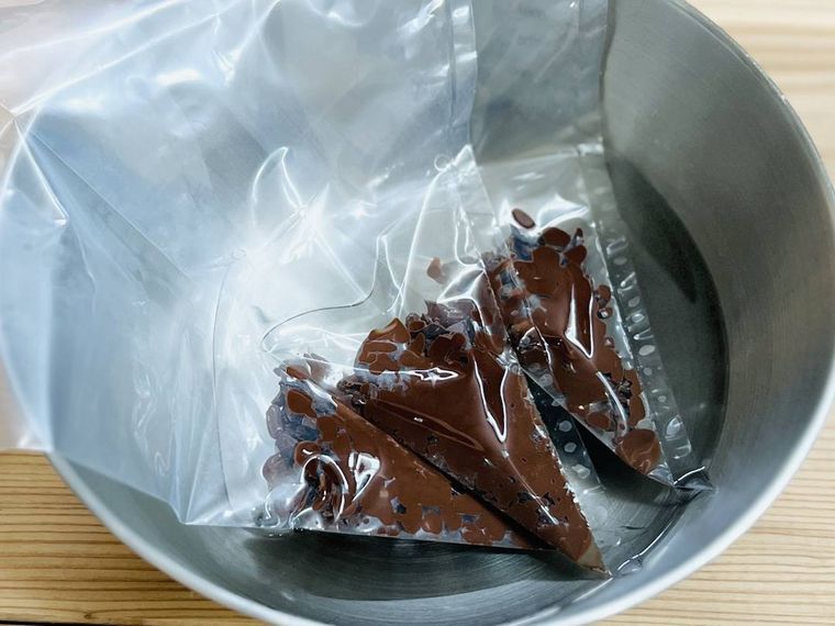 チョコレートが入った絞り袋をぬるま湯に浸している様子