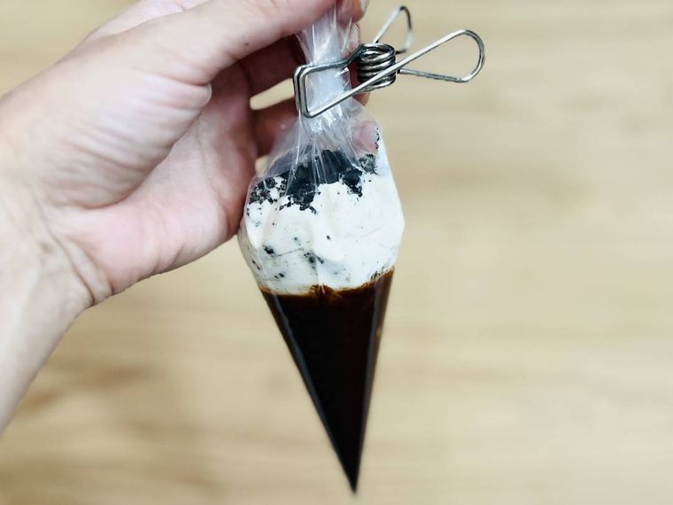 ホイップクリームが入った絞り袋の口を洗濯バサミで留めた様子