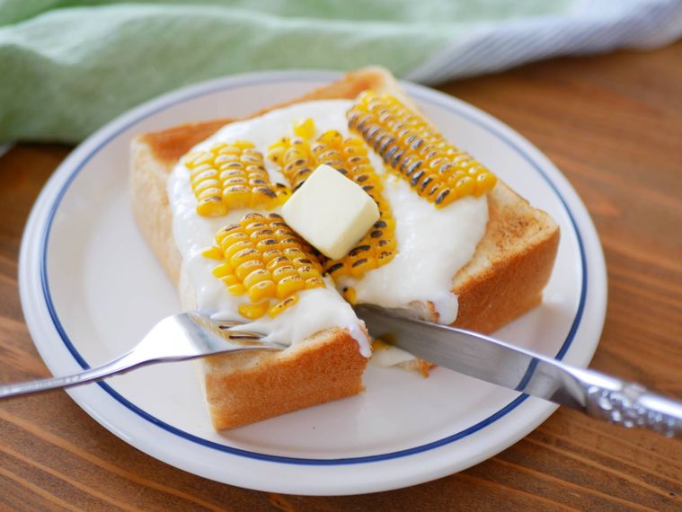 とうもろこしトーストをフォークとナイフで切り分けて食べる様子