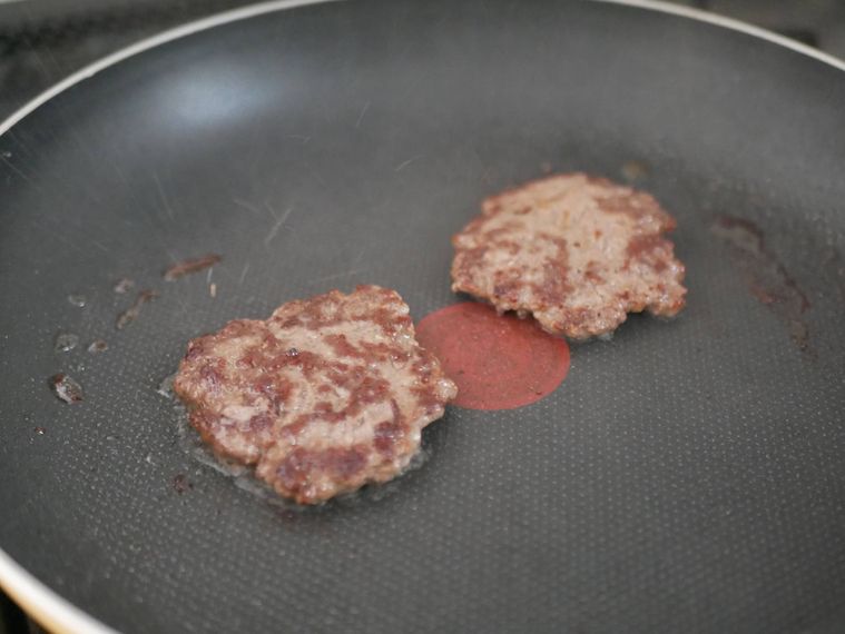 クローズドバーガーのパティをフライパンで焼く様子