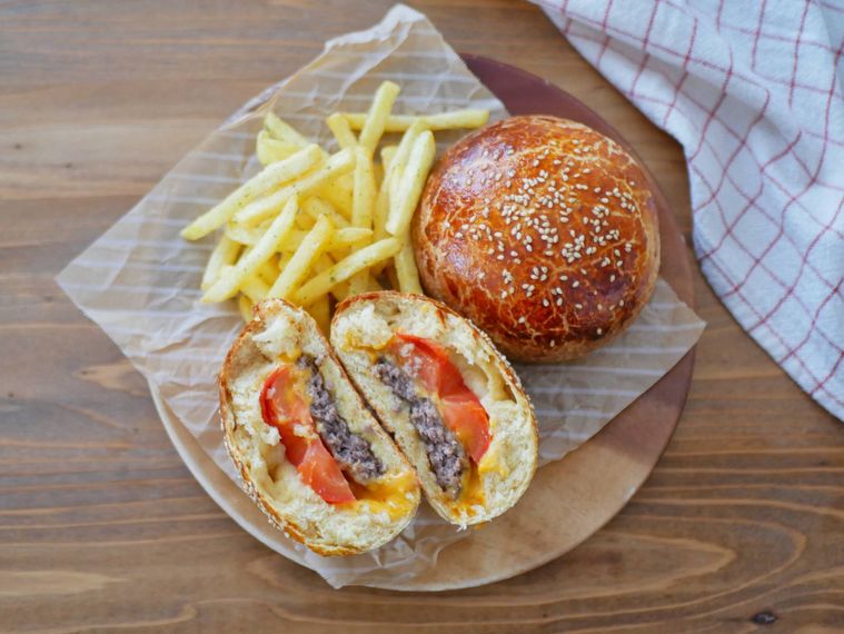 木製の皿に盛られたクローズドバーガー断面が見えている