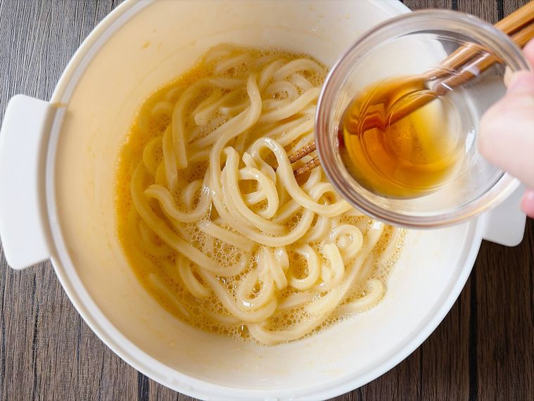うどんにめんつゆを加える様子