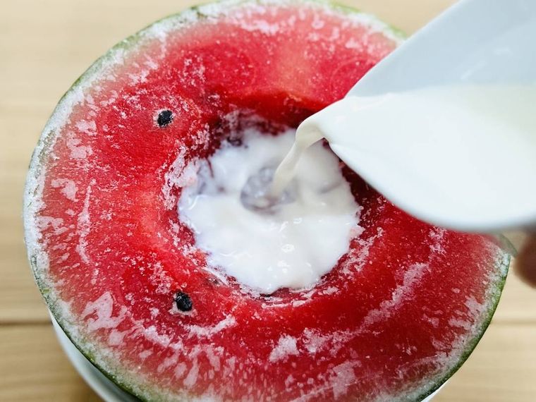 スイカのくぼみに牛乳をそそいでいる様子