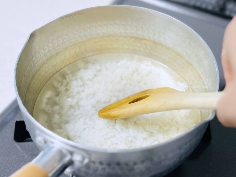鍋にご飯と水を入れ、ご飯をほぐしている様子