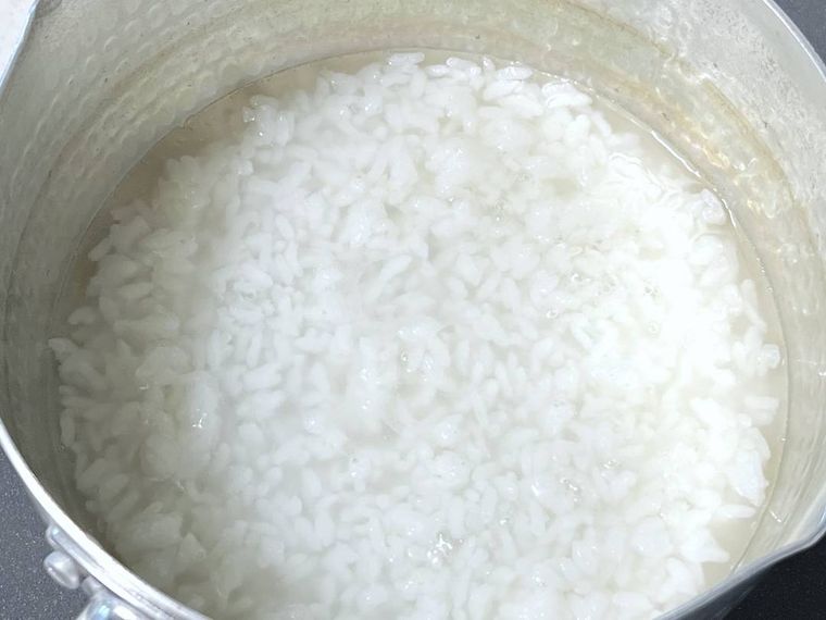 鍋にご飯と水を入れ、弱火で煮ている様子