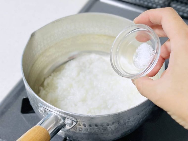 お粥に塩を加えようとしている様子