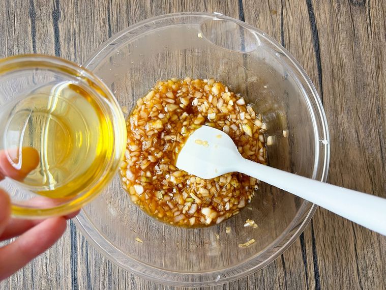 玉ねぎと調味料を合わせたものにサラダ油を加える様子