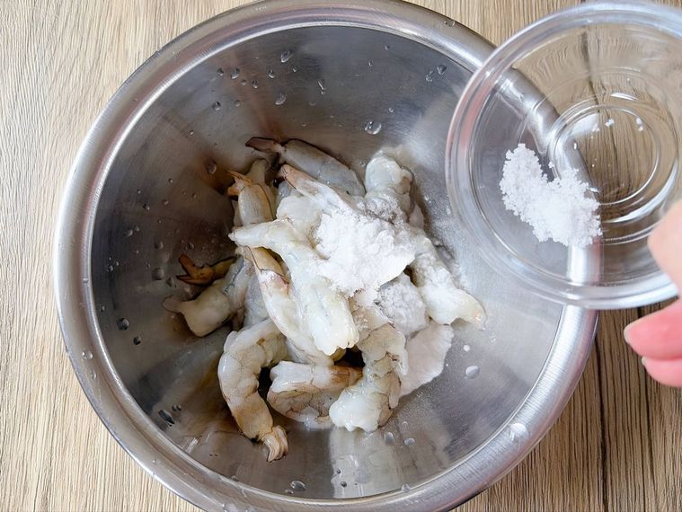 ボウルにむきえび、塩、片栗粉を入れる様子