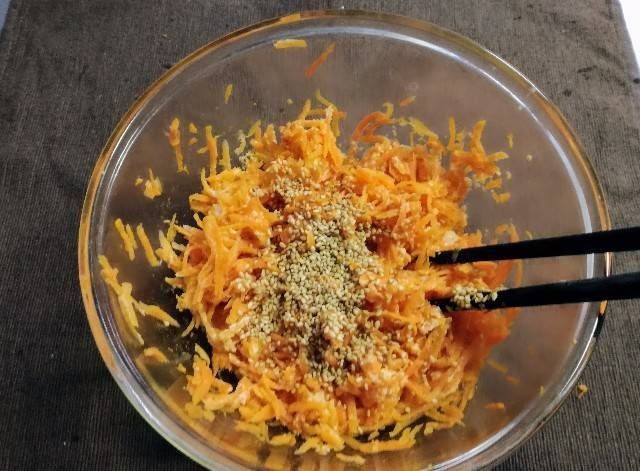 にんじんしりしりに白いりごまをふりかけている様子