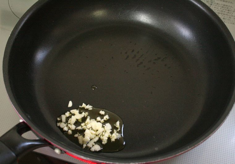 フライパンににんにくとオリーブオイルを入れた様子