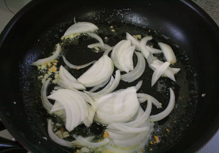 フライパンで玉ねぎを炒めている様子